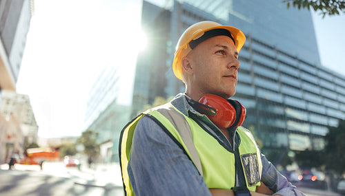 Thoughtful workman standing in the city