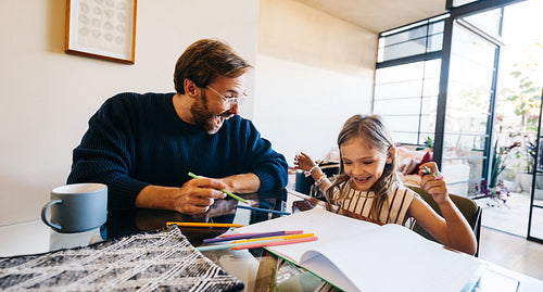 Father and daughter draw together at home