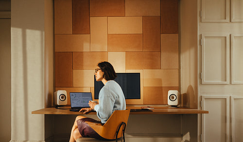 Middle-aged woman sits pensively at her office desk with a cup of coffee
