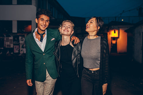 Friends walking down street in the evening
