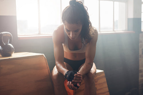 Female athlete taking rest after fitness training at gym