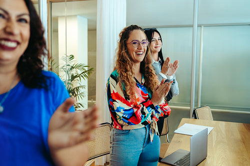 Female coworkers applauding a successful presentation