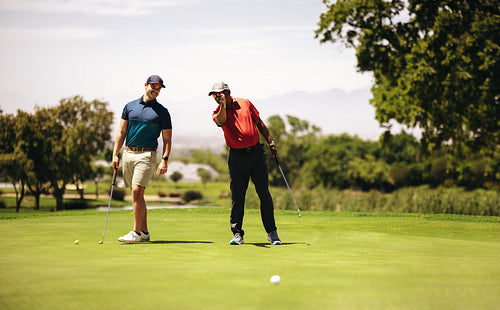 Two sportsmen at a golf resort planning the perfect shot