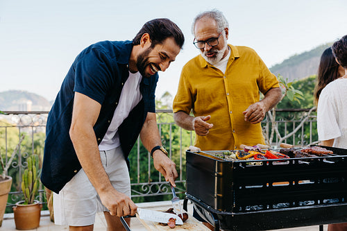 Family barbecue gathering with diverse food on a sunny balcony