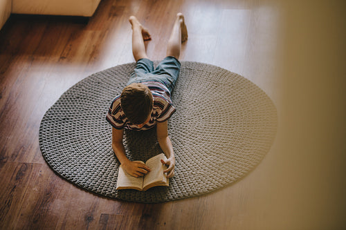 Boy reading a book at home