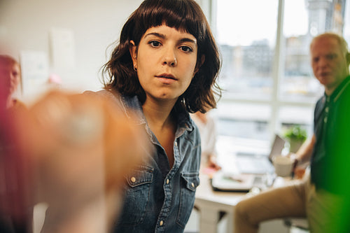 Woman brainstorming using adhesive notes on glass wall