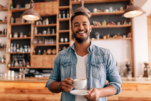 Handsome man in a cafe with cup of coffee