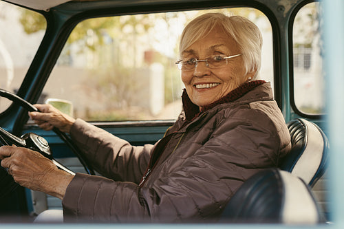 Senior woman driving a car on winter day
