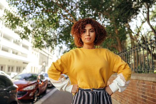 Assertive teenage girl standing on a sidewalk