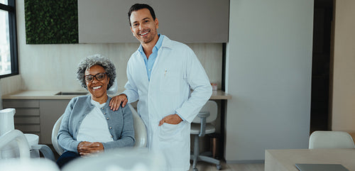 Dentist and senior patient smiling after successful consultation