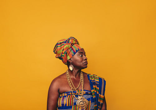 African woman wearing elegant cultural clothing in a studio
