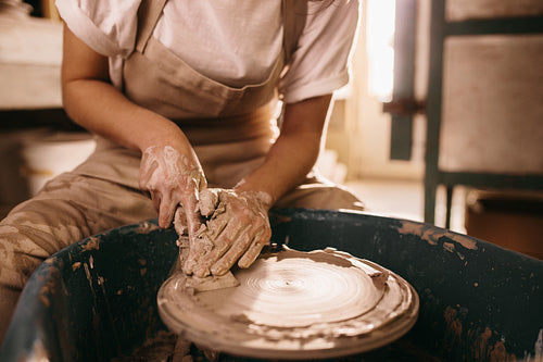Potter moulding clay on pottery wheel