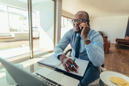 Businessman talking over mobile phone at work