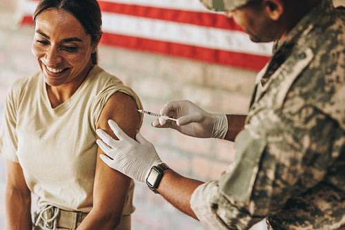 Happy female soldier getting vaccinated against covid-19