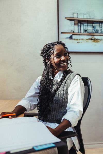 Smiling young architect sitting at desk in an architectural studio