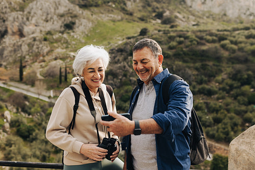 Happy senior couple having a video call while hiking