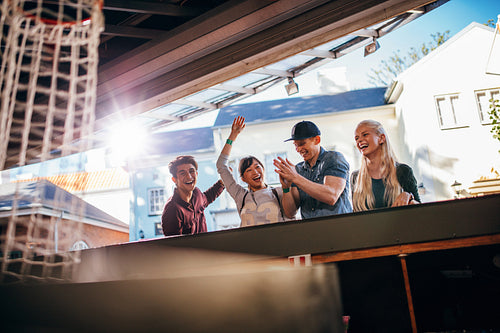 Friends playing basketball game at amusement park 