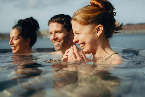 A smiling adult group gathers at the spa by the waterfront.