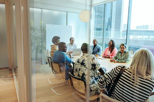 Creative team meeting in modern advertising agency office around a large conference table