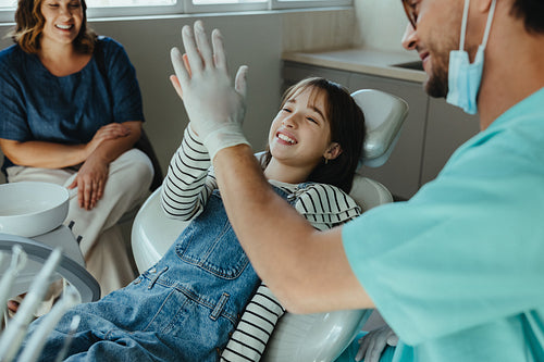 Her dentist shares a happy moment with a child during a family clinic visit