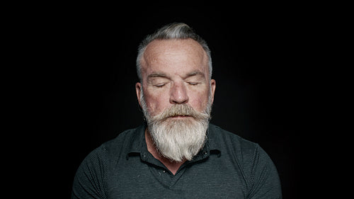 Bearded senior man with his eyes closed