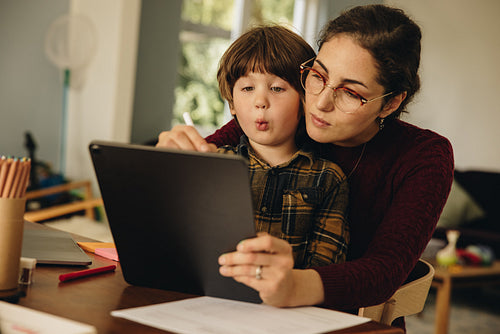 Mother and son using digital tablet at home