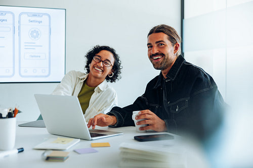 Two designers discuss UX ideas at a meeting