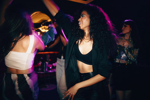 Group of young friends dancing together at a vibrant nightclub party