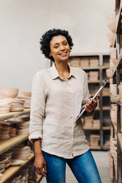 Ethnic female ceramist smiling at the camera in her shop