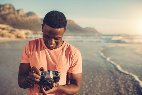 Young man checking photos in digital camera