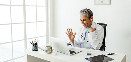 Virtual consultation in a doctor’s office: Friendly female doctor video calling a patient