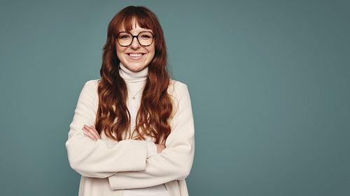 Woman with eyeglasses smiling in a studio