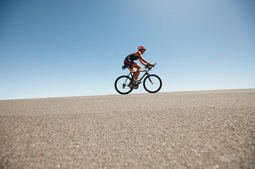 Female cyclist on a country road training for triathlon
