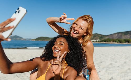 Friends taking a joyful selfie displaying peace signs in a moment of happiness and fun