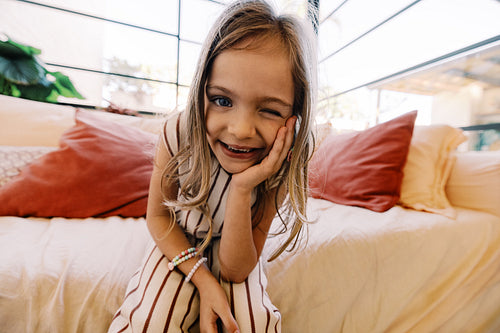 Child smiles and winks on couch