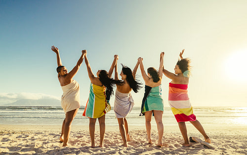 Young women cheering happily at the beach