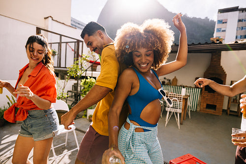 Friends dancing and enjoying a sunny summer day outdoors in Rio de Janeiro