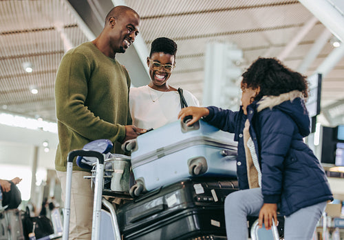 African family waiting at airport with luggage