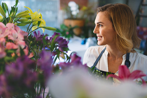 Smiling woman working at indoor plant nursery
