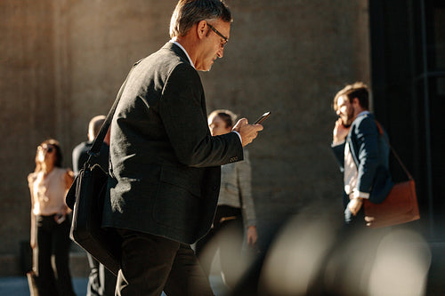 People walking to office in the morning busy with their mobile phone