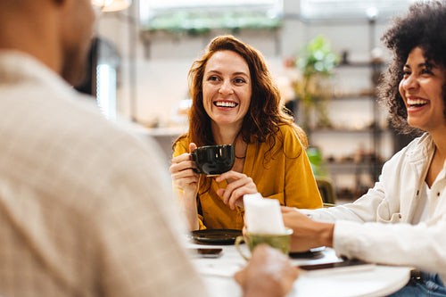 Fun coffee date with friends: Group of young people chatting in a coffee house