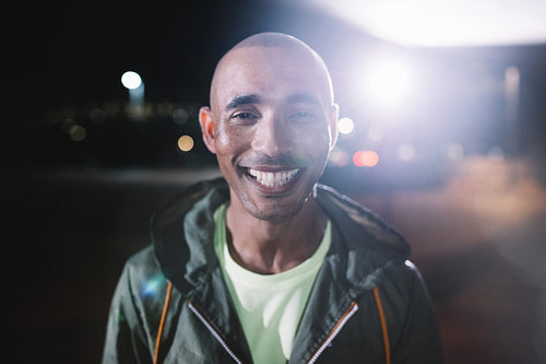Smiling runner standing in city at night