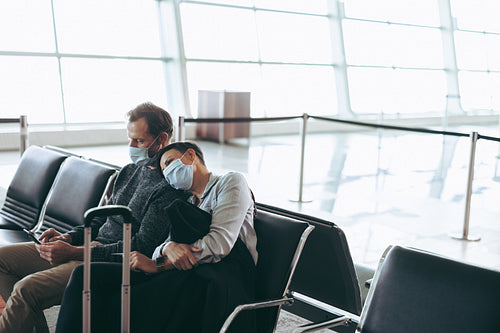 Tourist with face masks waiting at departure lounge