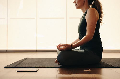 Mature woman doing a yoga exercise at home