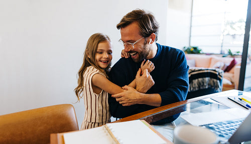 Father and daughter share warm hug at home
