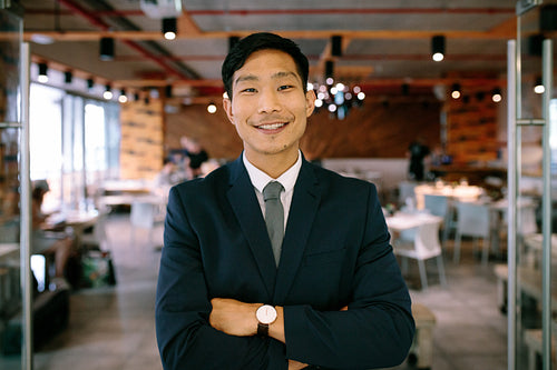 Confident young businessman standing at coffee shop