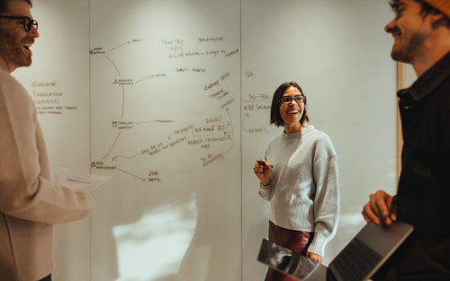 Team brainstorming around a whiteboard in office