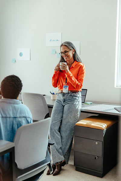Businesswoman enjoying coffee and talking to a colleague