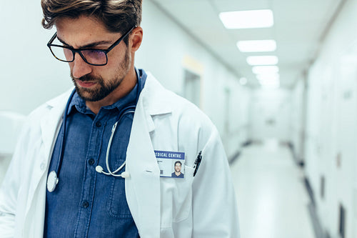 Male doctor in hospital corridor.