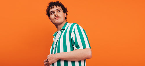Queer man looking away in a studio